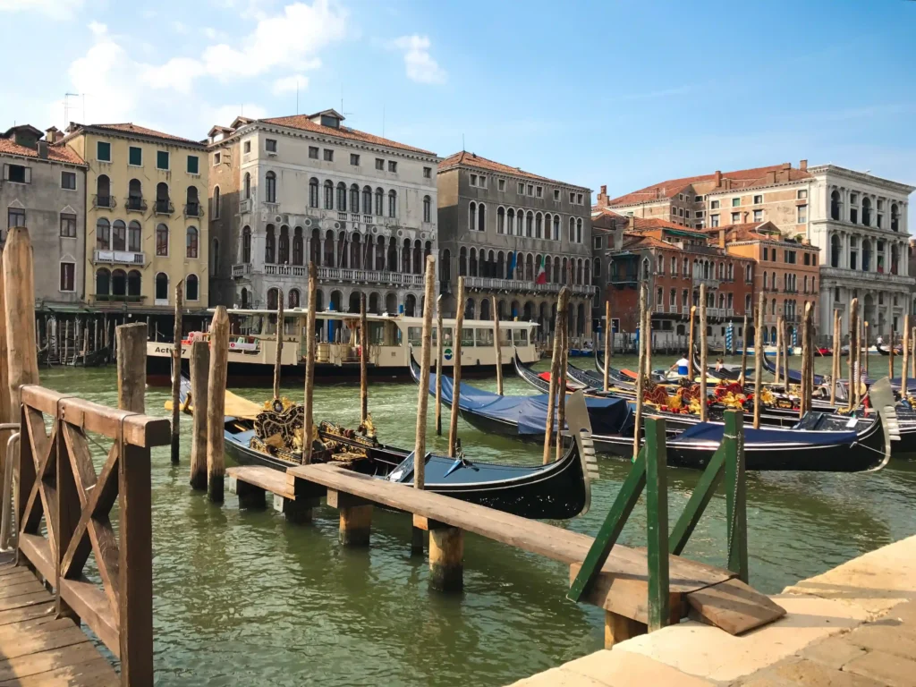 View of the Grand Canal in Venice with docked gondolas and beautiful houses lining the water.