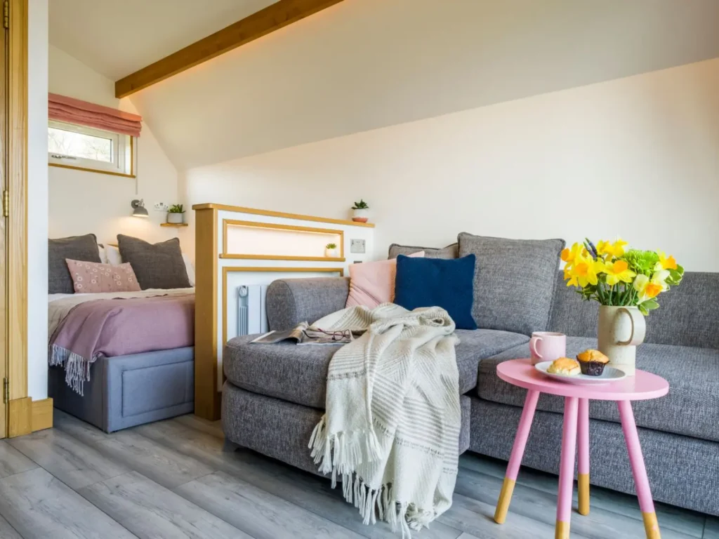 The interior of the Inchmurrin glamping pod at Bonnie Barns showing sofa and bed. 
