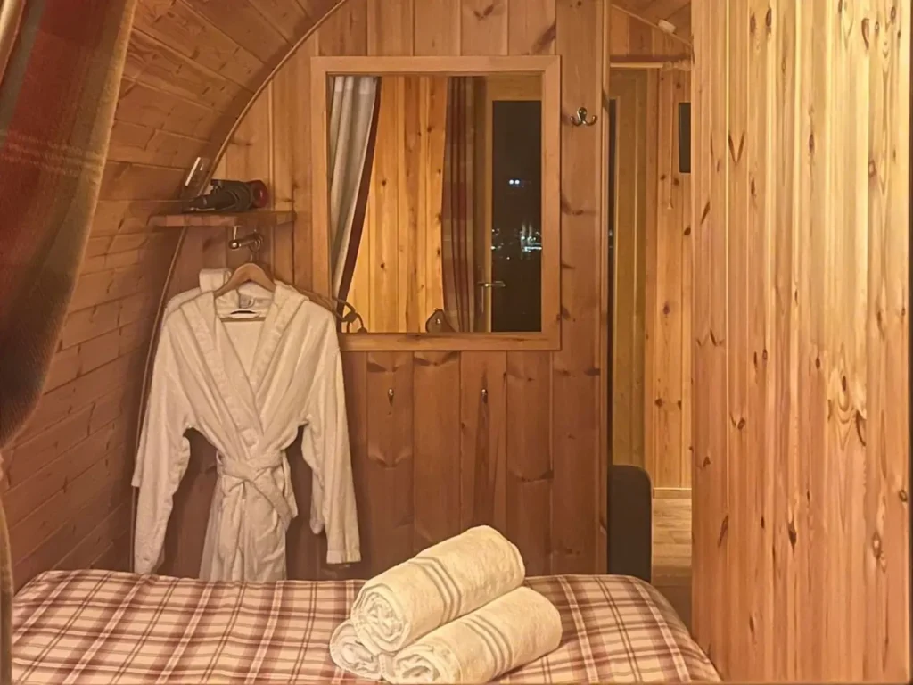 Interior of Stoneymallon over Loch Lomond cabin showing towels on bed and dressing gowns.