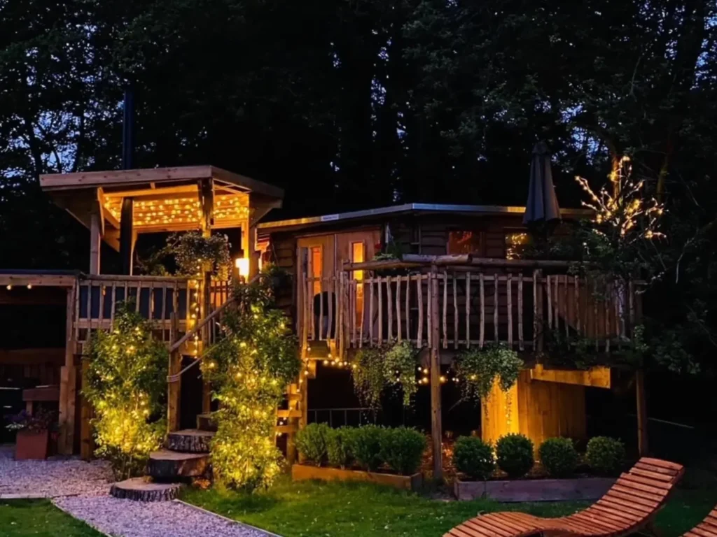 Exterior of the Loch Lomond Hideaways Treehouse lodge at night.