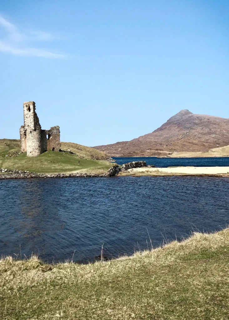Ardvreck Castle on the NC500 in Scotland on a sunny day.