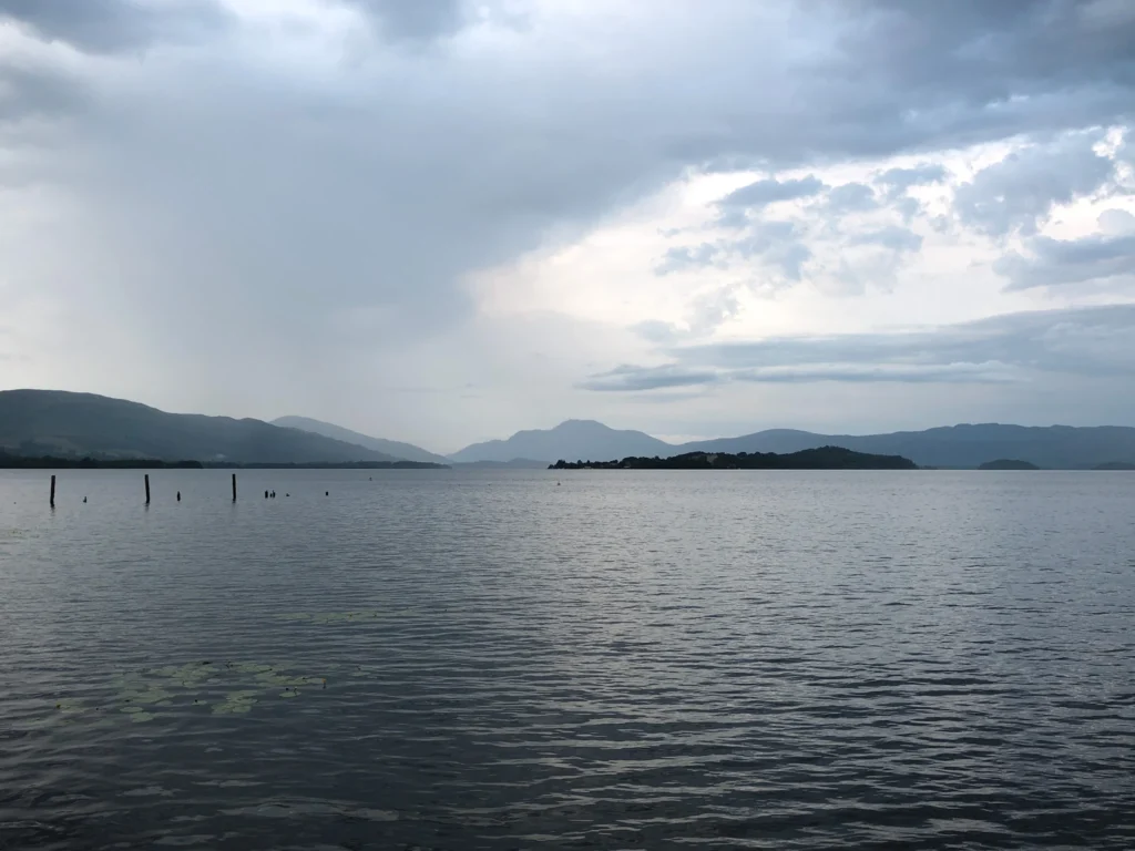 Viewpoint for Duck Bay Marina pier over Loch Lomond and its islands on a cloudy day.