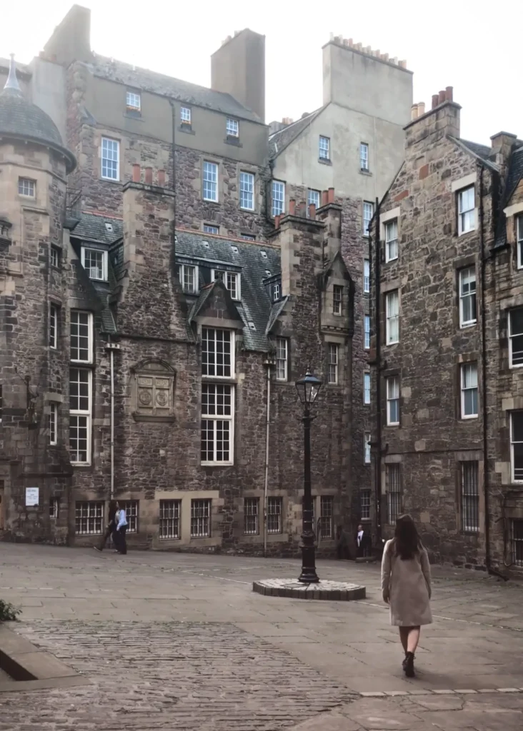 Girl walking in Makars Court in Edinburgh on a gloomy day.
