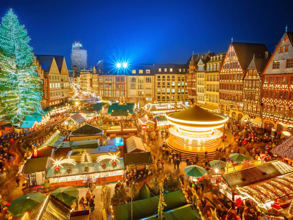 Christmas market in Frankfurt at night, packed with stalls and fun fair rides.