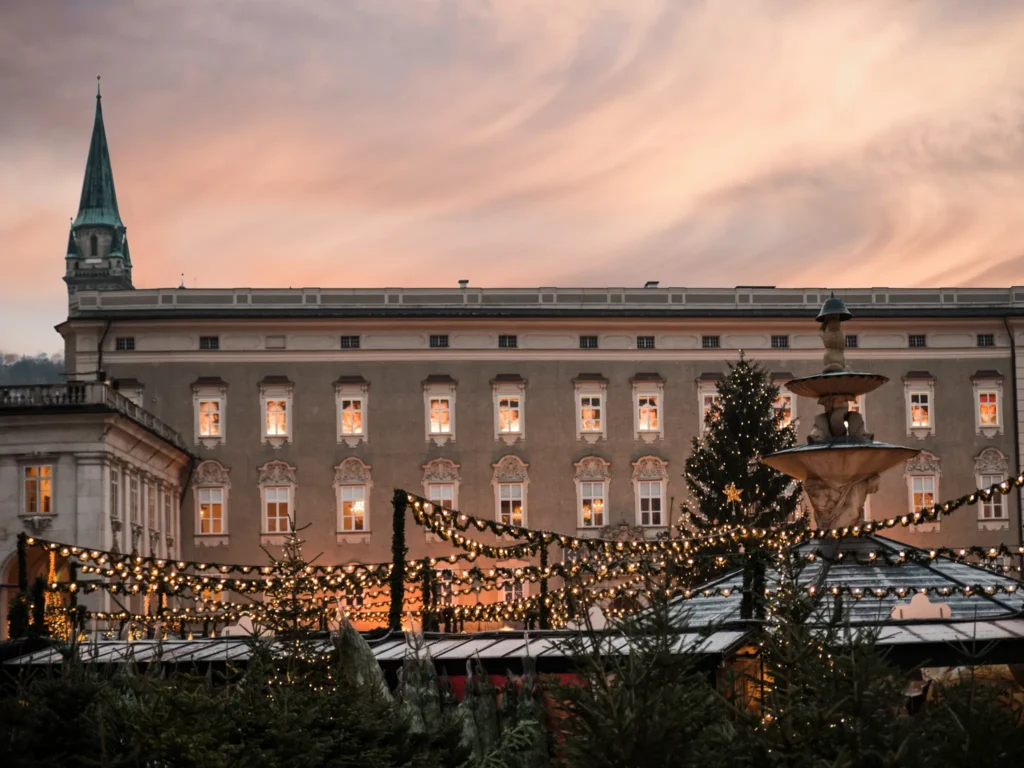 Traditional christmas market at dome place salzburg at sunset.