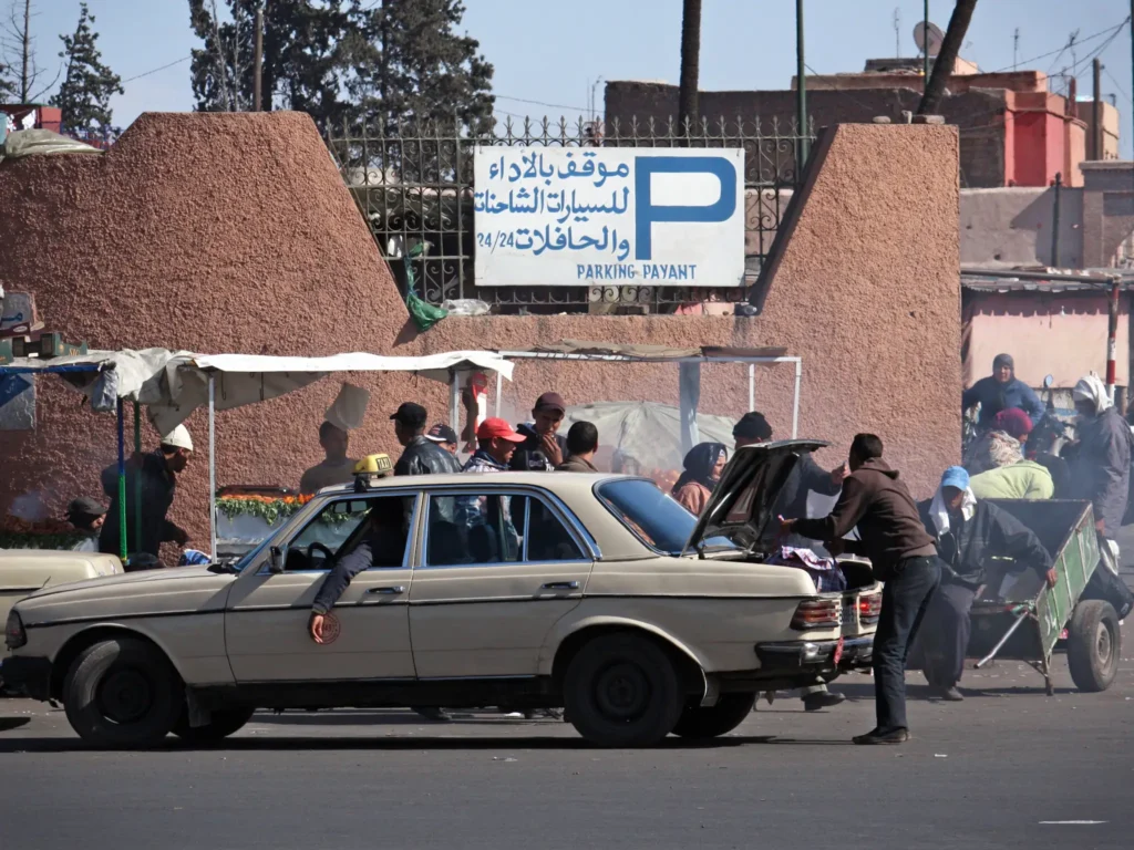Cars and people near a parking lot in Marrakech.