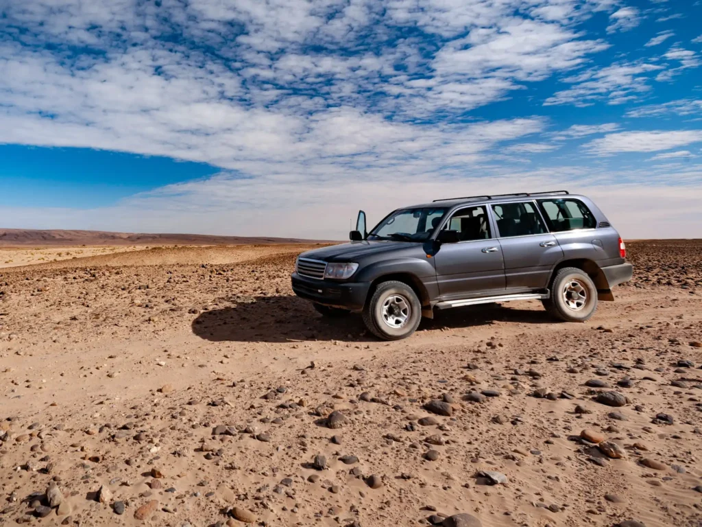 Off road vehicle stopped with door open in Moroccan desert.