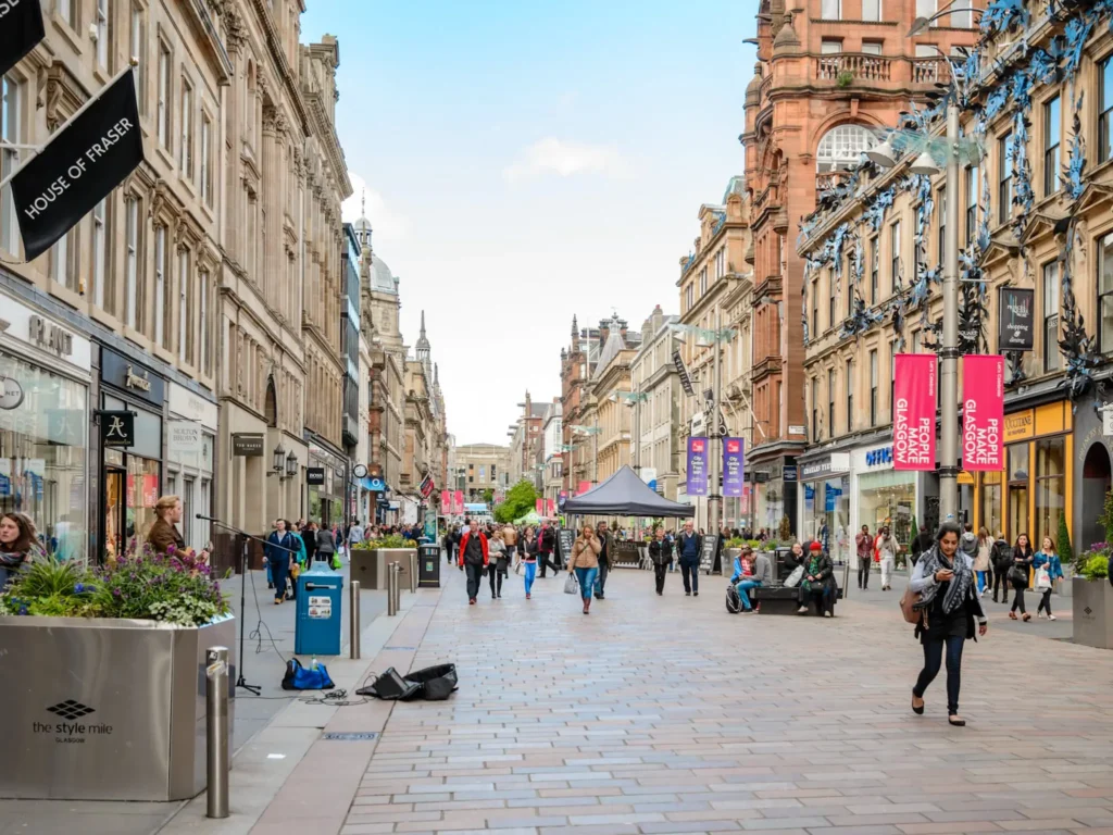 Busker and pedestrians on buchanan street in Glasgow city centre.