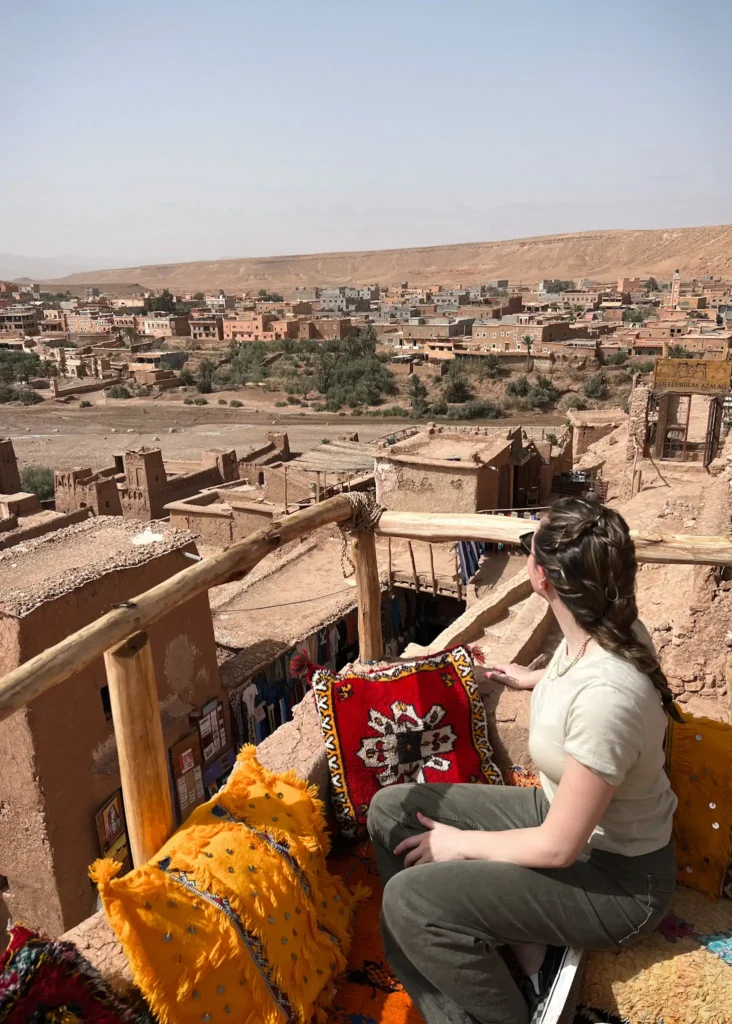 Girl sitting with back to the camera in a cafe in Ait Ben Haddou overlooking the town.