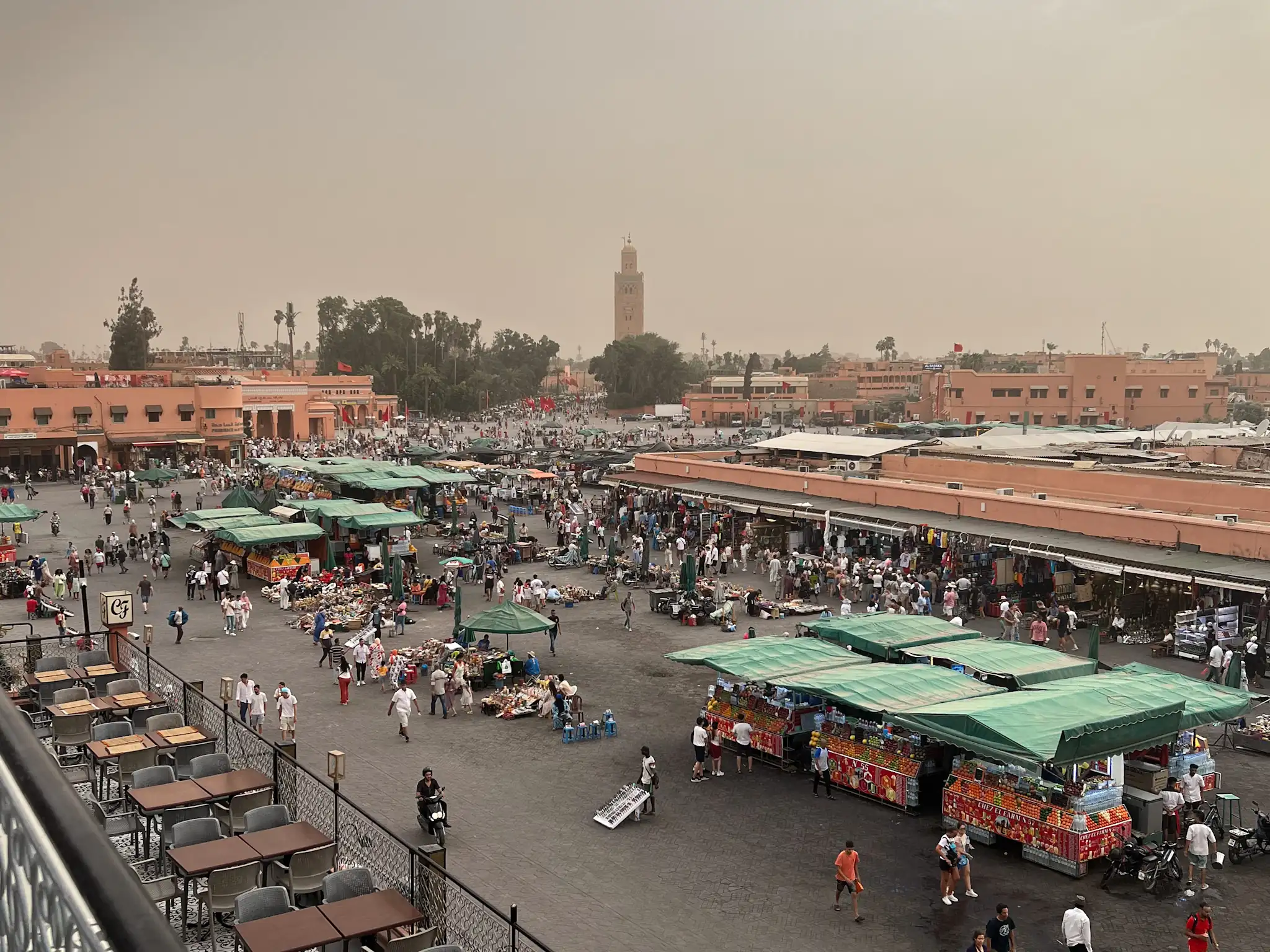 Jemaa el-Fnaa in Marrakech at sunset as people are setting up stalls and crowds are starting to gather.