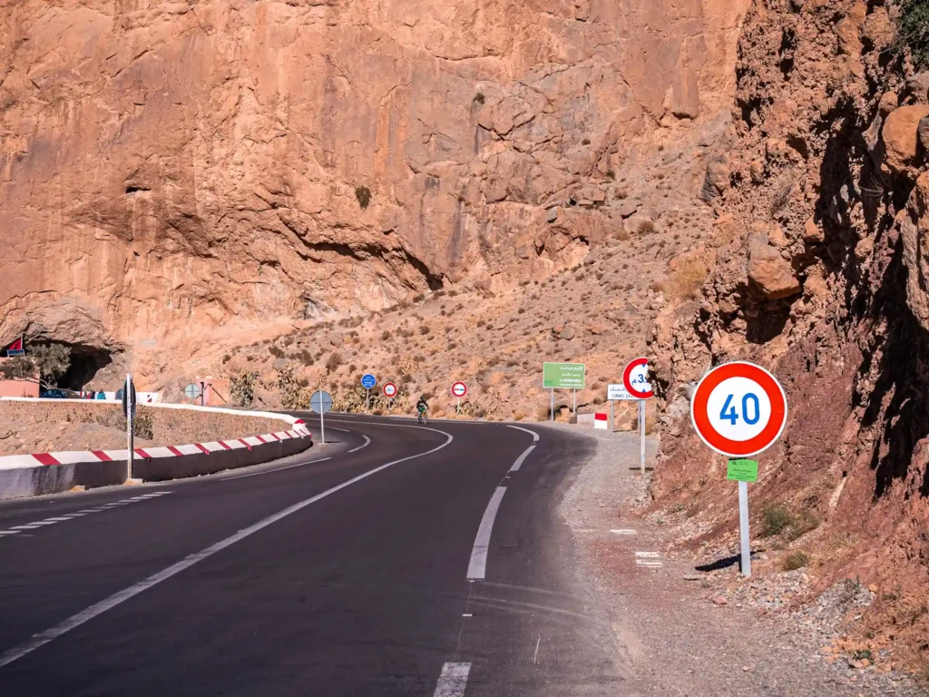 Winding Morocco mountain road with speed limit sign.