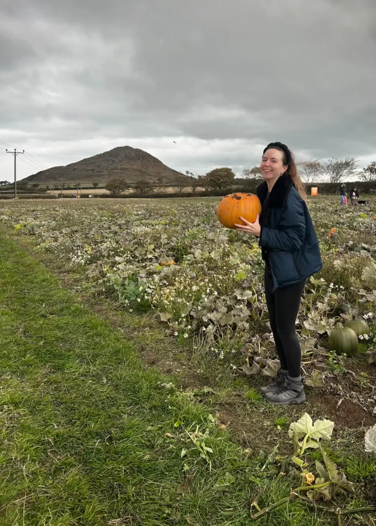 Girl laughing at the camera while holding a pumpkin at Balgone Estate.