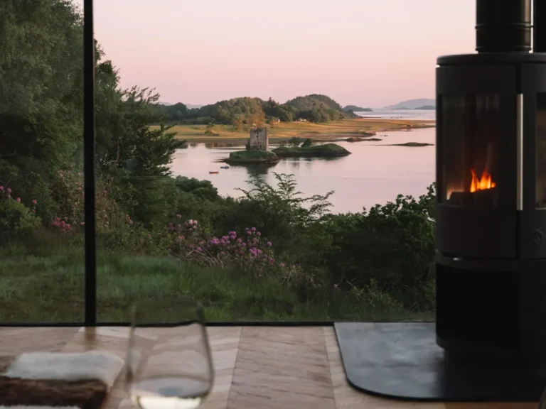 The view over Castle Stalker from the Stormhouse lodges at sunset.