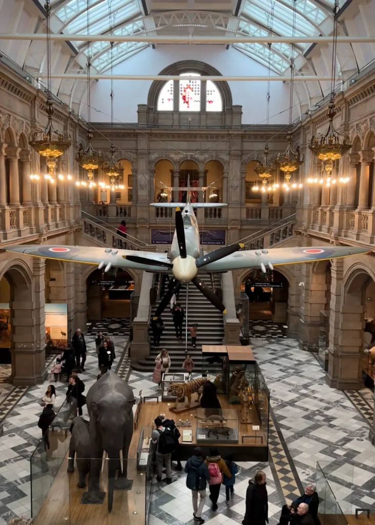Plane hanging overhead with a stuffed elephant exhibit underneath in one of the galleries in Kelvingrove Museum in Glasgow.