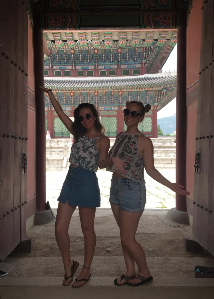 Girls posing in front of Gyeongbokgung Palace in Seoul.