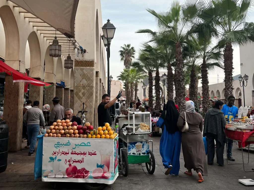 Agadir Souks with juice vendor and palm trees.