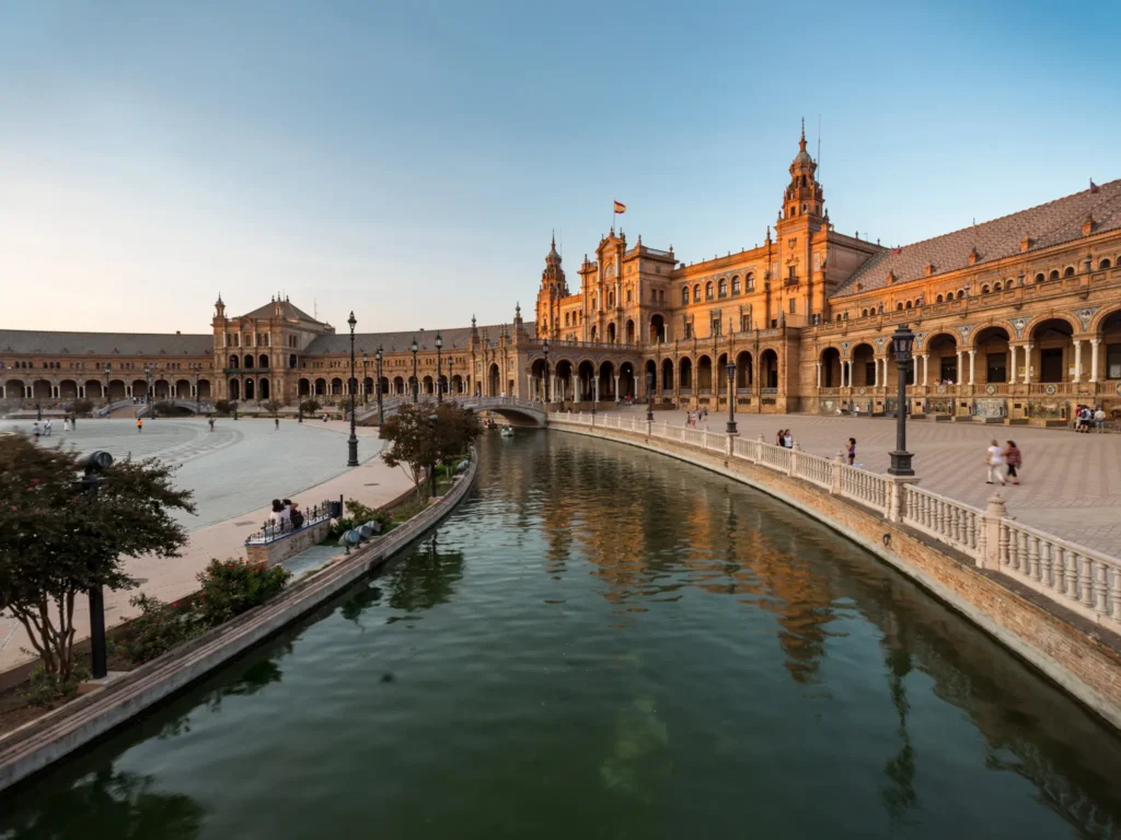 Plaza de España in Seville as the sun is setting on a clear sunny day.