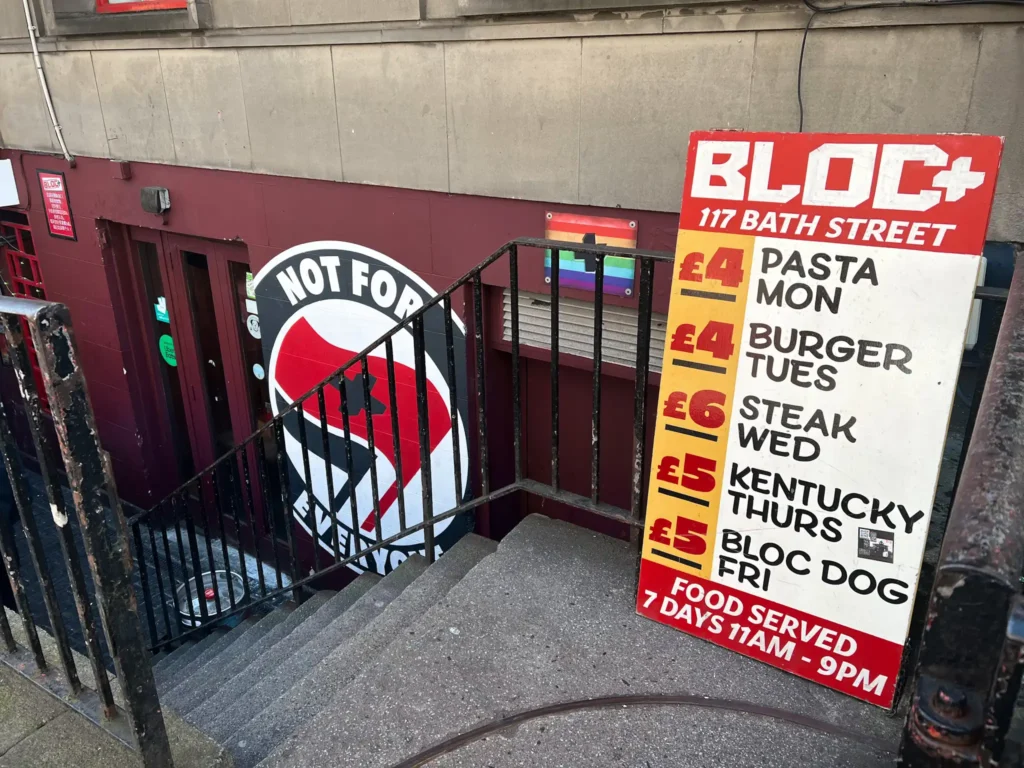 Outside of Bloc+ in glasgow showing stairs down to the bar and restaurant, and the board with food deal nights.