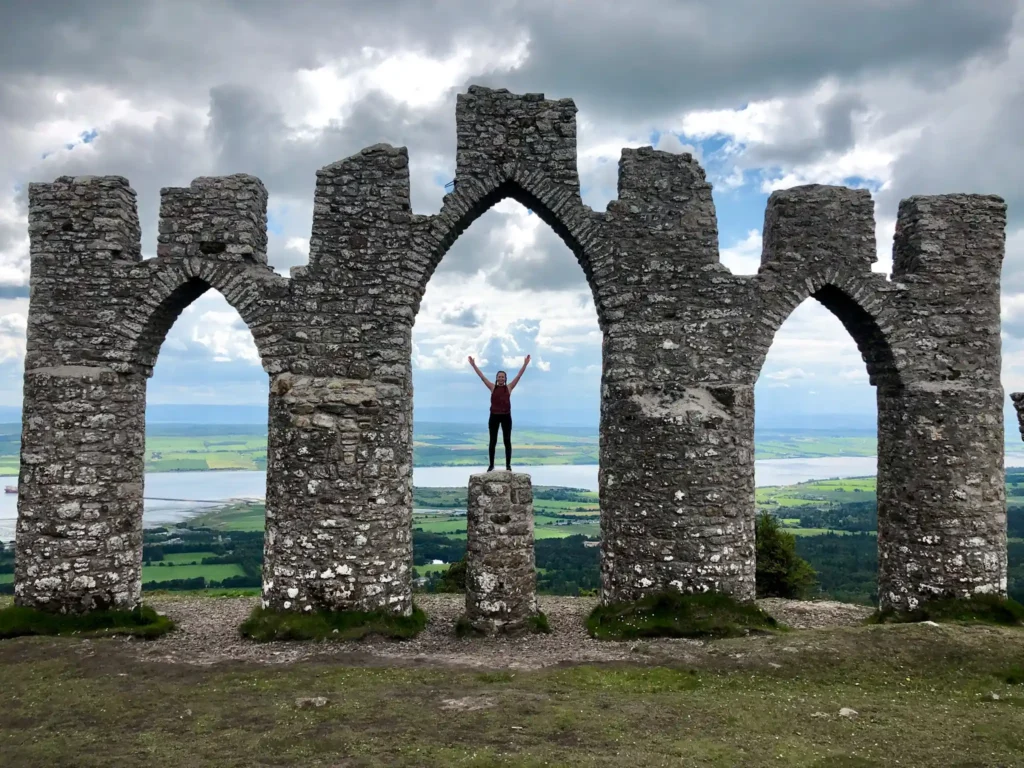 Girl standing on a rock at Fyrish Monument with Cromarty Firth in the background.