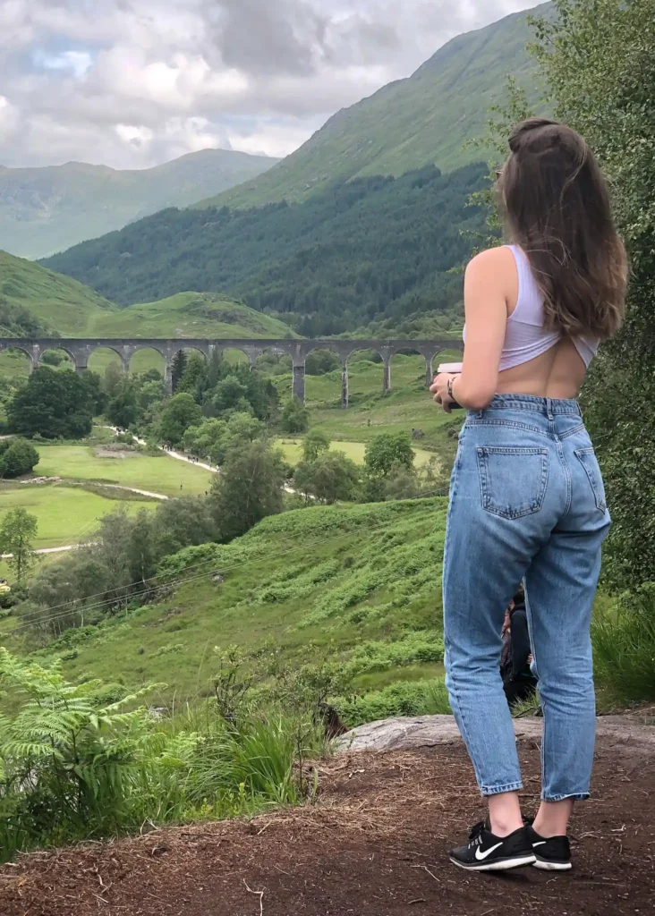 Girl standing with back to camera looking at the Glenfinnan Viaduct. 