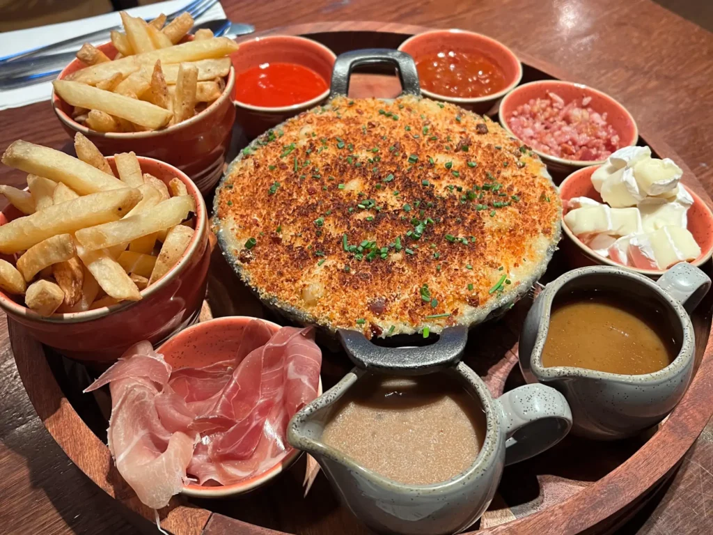 Mac 'n' cheese sharing platter from Sloans in Glasgow city centre showing chips, sauces, cheeses, and ham.