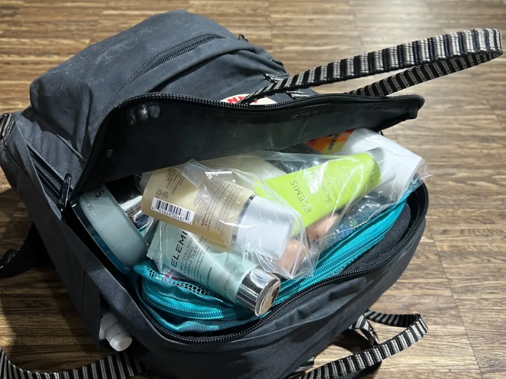 Open Fjällräven Kånken Classic Backpack packed far too full with toiletries bulging out.