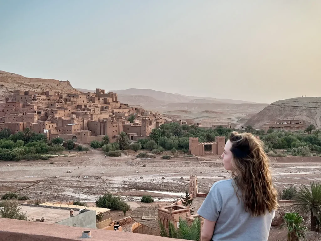 Girl standing on a balcony watching the sunrise over Ait Ben Haddou.