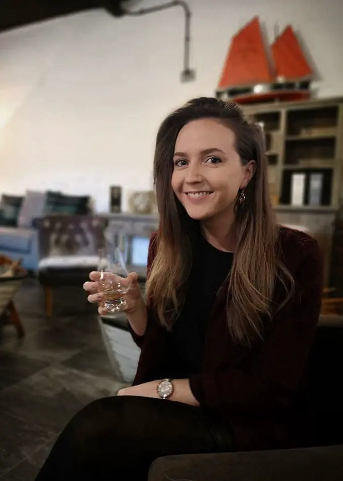 Girl smiling at the camera holding an Old Pulteney dram.