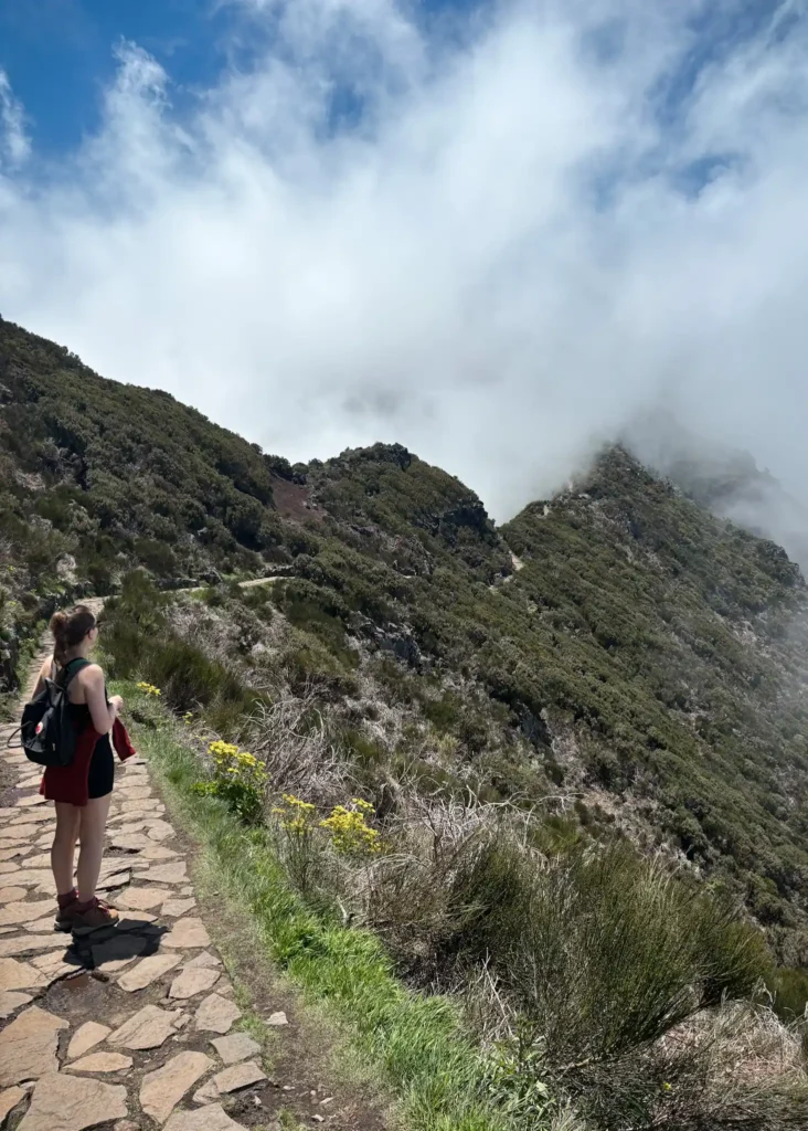 Girl with back to the camera in hiking clothes on a trail in Maderia.