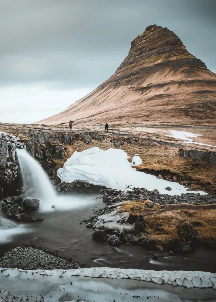 Kirkjufell is a 463-meter-high mountain in Iceland with nearby waterfalls.