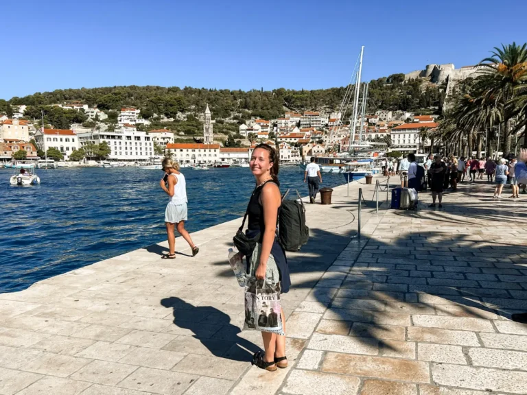 Girl standing smiling at the camera on Hvar Old Town promenade.