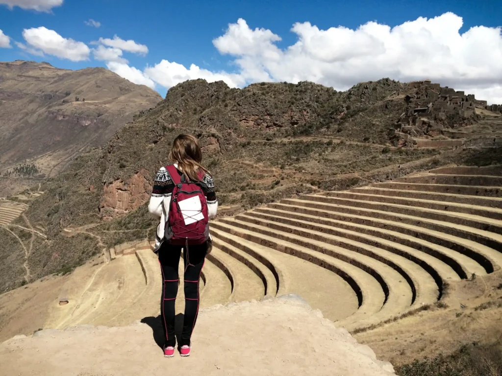 Girl standing with her back to the camera overlooking Ollantaytambo Peru