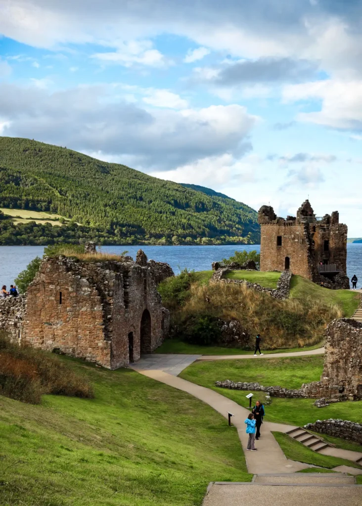 urquhart castle on a sunny day with water in the background