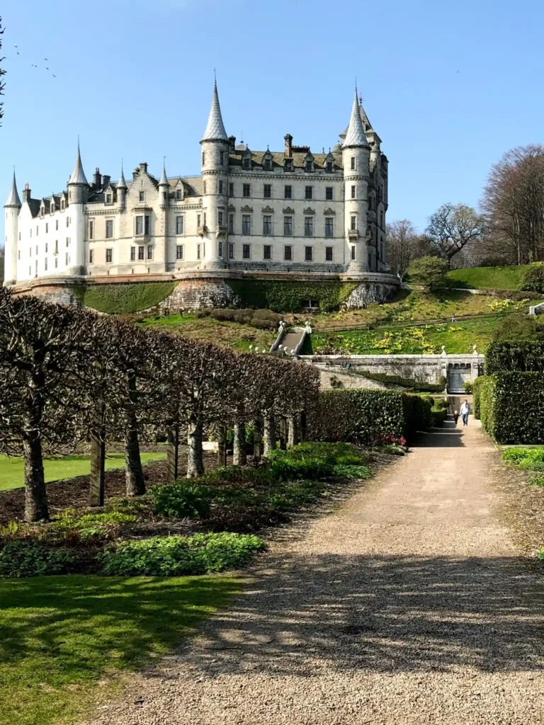 Exterior of Dunrobin Castle and gardens on a sunny day.