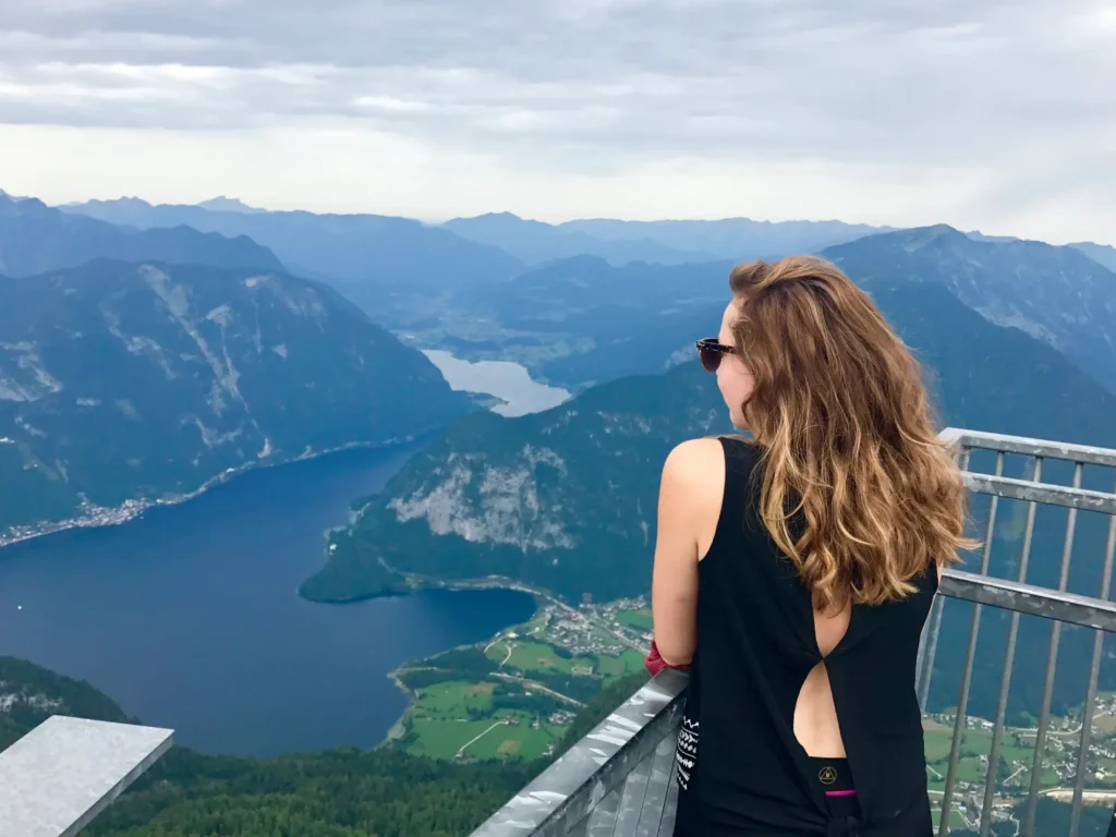 Girl standing with her back to the camera on 5fingers viewing platform above Hallstatter See.