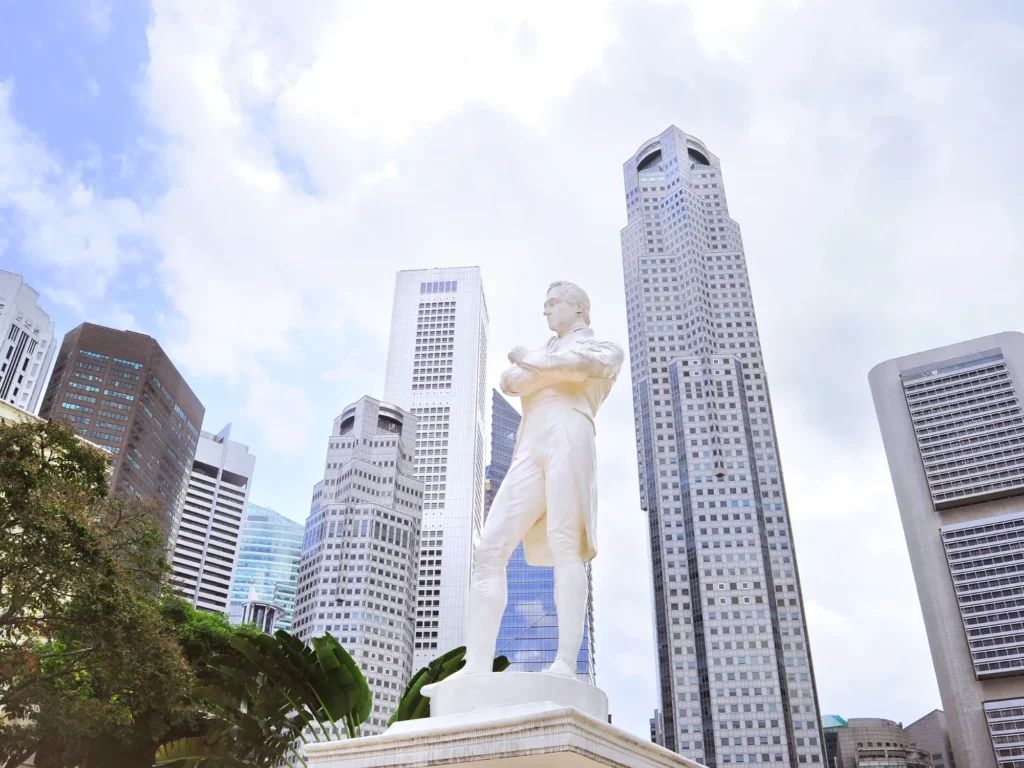Sir tomas stamford raffles monument with skyscrapers in the background.