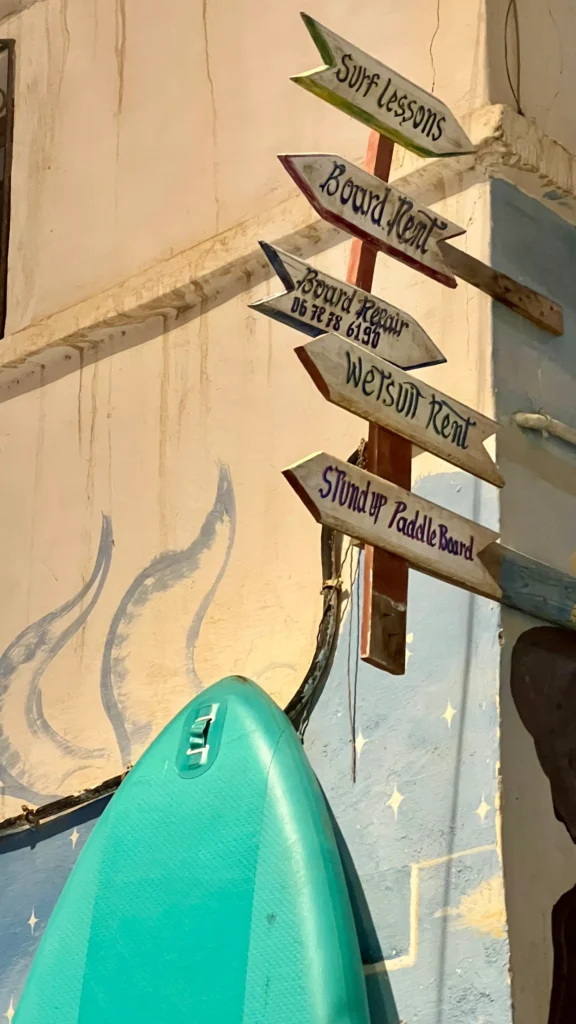 Signs point to surf lessons, board rent and wetsuit rental in Taghazout.