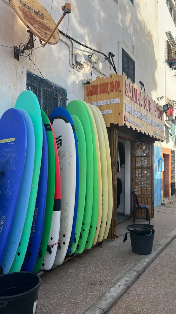 Surf shop in Taghazout showing surfboards all lined up outside on the street.